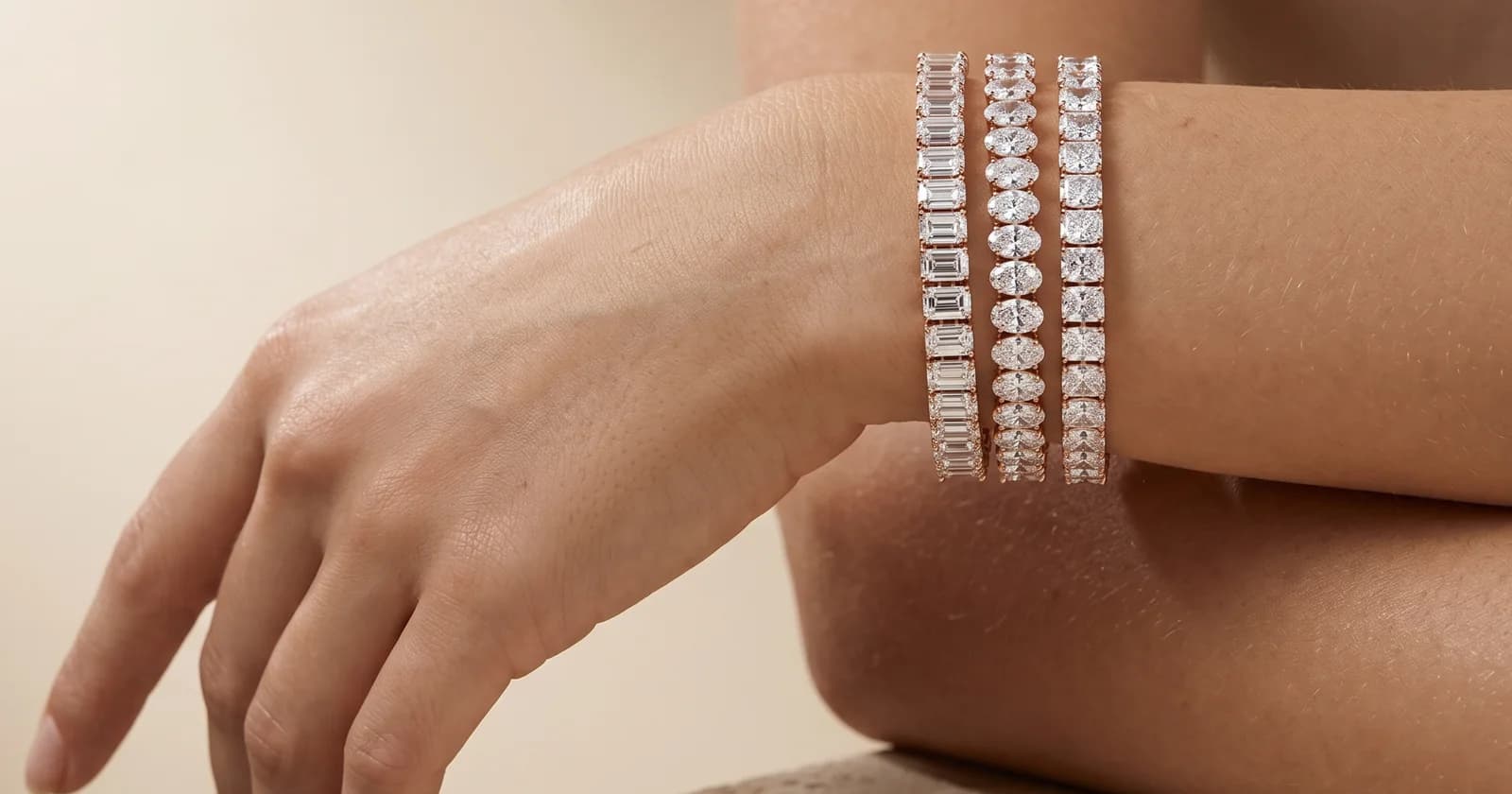 Three diamond tennis bracelets stacked on the wrist — emerald, oval and radiant cuts in rose gold, DAZZ
