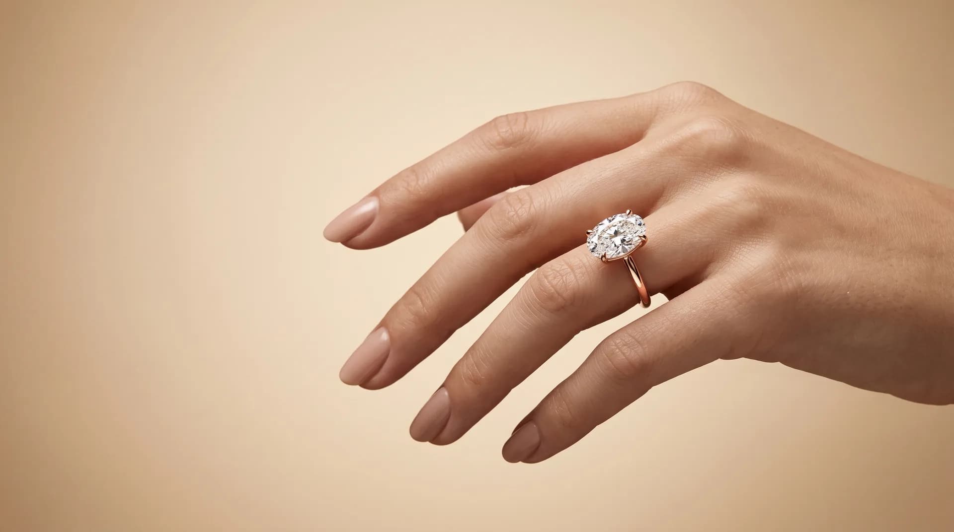 Oval diamond engagement ring in rose gold on a styled hand — studio campaign photo, DAZZ