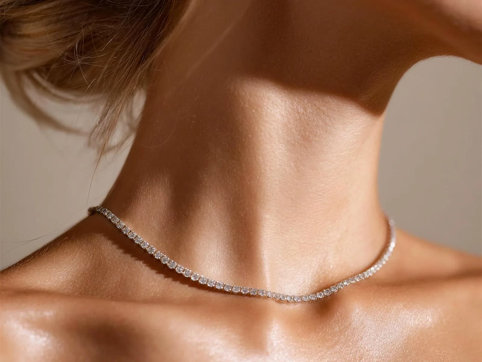 Delicate diamond tennis necklace in white gold on a woman’s neck — soft-light close-up, DAZZ